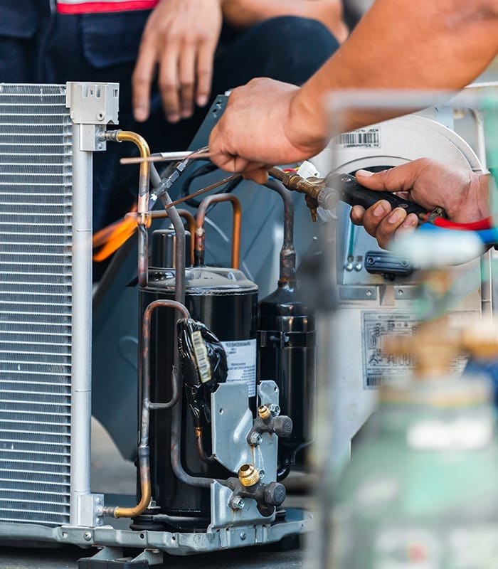 group of technicians repairing air conditioner unit peyton co