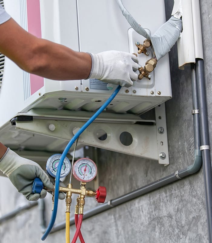 hvac technician hands close up measuring commercial unit voltage peyton co