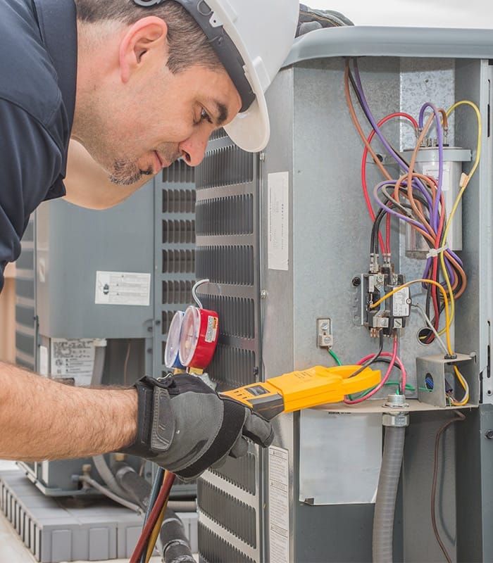 hvac technician with protection gloves repairing commercial unit peyton co